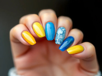 Women’s almond shape nails in yellow and different shades of blue in a water look