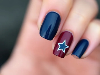 Navy nails with maroon ring finger with white star outline