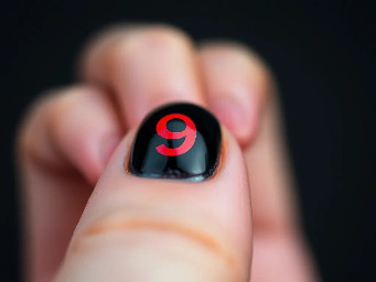 Black nail with a red letter 9 on it
